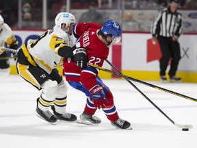 Montreal Canadiens' Cole Caufield holds off Pittsburgh Penguins' Marcus Pettersson during third period in Montreal on Thursday, Nov. 18, 2021.