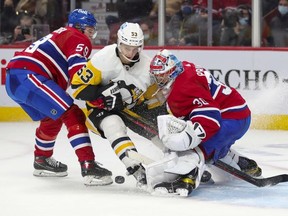 Pittsburgh Penguins' Teddy Bluger cuts between Montreal Canadiens defenceman Mattias Norlinder and goalie Cayden Primeau during second period in Montreal Thursday, Nov. 18, 2021.