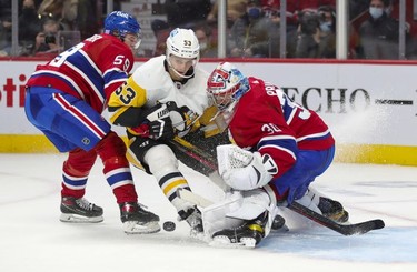 Pittsburgh Penguins' Teddy Bluger cuts between Montreal Canadiens defenceman Mattias Norlinder and goalie Cayden Primeau during second period in Montreal Thursday, Nov. 18, 2021.