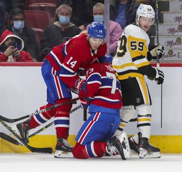 Montreal Canadiens' Nick Suzuki, left, collides with teammate Tyler Toffoli next to Pittsburgh Penguins' Jake Guentzel during first period in Montreal Thursday, Nov. 18, 2021.