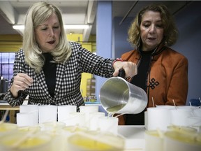 Riau Canada director of operations Louise Bourassa, left, pours hot candle wax into a mold while president and founder Franca Ciambella looks on at their Montreal plant on Thursday Nov. 18, 2021.