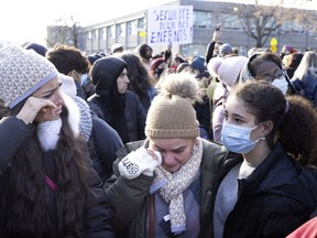 Two women wipe their tears after observing a moment of silence during a memorial for slain student Thomas Trudel in Montreal, on Saturday, November 20, 2021.