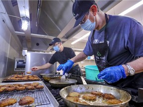 Zera Café kitchen assistant Eyal Faitelis, right, and chef Matthew Schnarch fry up latkes for Hanukkah at Shaare Zion Synagogue in Montreal on Nov. 24, 2021.