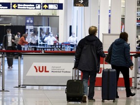 Travellers walk through Trudeau International Airport in Montreal on Monday, November 29, 2021.