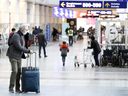 Travelers make their way to check-in for their flights leaving Pierre-Elliott Trudeau International Airport in Montreal, Monday, Nov. 29, 2021.