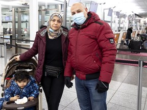 Travellers Ahmed Saleh, right to left, his wife Eman Nossir and son Ali Saleh are forced to find another way to travel after his flight was cancelled at the last moment, at Pierre-Elliott Trudeau International Airport in Montreal, on Monday, November 29, 2021.