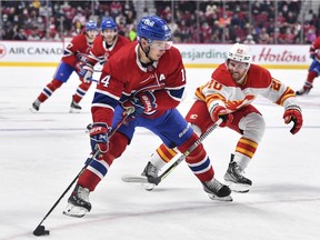 Canadiens' Nick Suzuki skates the puck against Flames' Blake Coleman Thursday night at the Bell Centre. "I'm just trying to play a little more gritty, get into the game early," Suzuki said about his recent improved play.