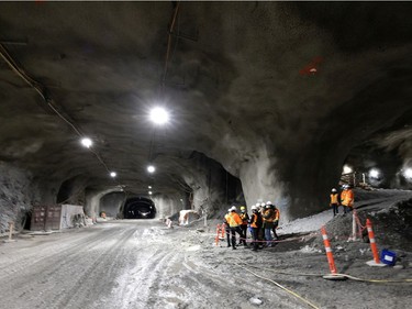 Members of the media are dwarfed by the REM tunnel, at about 72 meters below the surface at the Edouard Montpetit station, seen in Montreal, on Wednesday, Nov. 24, 2021.