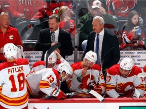 Associate coach of the Flames Kirk Muller, left, and head coach Darryl Sutter work the bench during the game against the Devils last month.