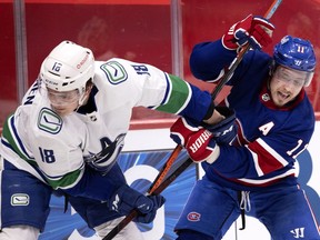 Canadiens' Brendan Gallagher (11) tries to shake off Vancouver Canucks' Jake Virtanen (18) in Montreal on March 20, 2021.