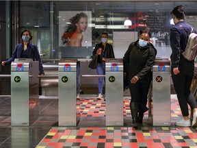 Commuters exit the Guy-Concordia métro station. "I can see the benefit of continuing to wear a mask while on a crowded métro, bus or plane," Fariha Naqvi-Mohamed writes.