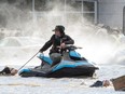 Cows that were stranded in a flooded barn are rescued by people in boats and a sea doo in Abbotsford, British Columbia, Nov. 16, 2021.