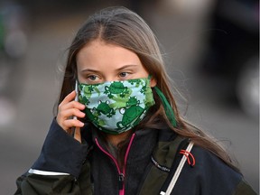 Climate activist Greta Thurnberg speaks on her phone as she walks to a session on the sidelines of the COP26 Climate Conference in Glasgow, Scotland on Nov. 3, 2021.