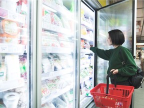 A young woman shops in the freezer aisle of a supermarket. In the early days of commercial frozen foods, peas were marketed as being “as gloriously green as any you will see next summer,” Joe Schwarcz writes.