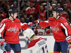 Capitals defenceman John Carlson, right, celebrates his power-play goal with centre Evgeny Kuznetsov during the first period Wednesday night as Canadiens' Cédric Paquette skates away.
