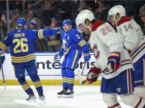 Sabres' Kyle Okposo and defenceman Rasmus Dahlin celebrate after Okposo's goal during the second period as Candiens's Chris Wideman and Nick Suzuki, right, skate away.