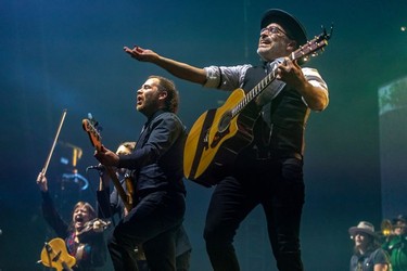 Marie-Annick Lépine, Karl Tremblay, hidden, Jérôme Dupras and Jean-François Pauzé, left to right, of the Quebec band Les Cowboys Fringants  at the Bell Centre in Montreal on Thursday, Nov. 25, 2021.