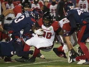 Ottawa Redblacks running back Timothy Flanders is tackled by Montreal Alouettes defensive back Patrick Levels during first quarter CFL football action in Montreal on Friday, Nov. 19, 2021.
