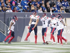 Montreal Alouettes defensive-end Jamal Davis (99) celebrates with teammates after recovering a fumble and returning it 19 yards for his first professional touchdown during the first quarter against the Blue Bombers in Winnipeg on Nov. 6, 2021.