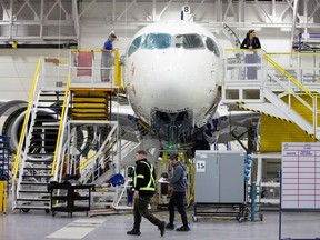 Employees work on an Airbus A220-300 at the Airbus facility in Mirabel in 2020.