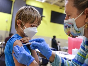 Dr. Sarah Linde with the Maryland Medical Reserve Corps gives Noah Starling, 7, his first COVID-19 vaccination, at Eastern Middle School, in Silver Spring, Maryland, U.S., November 6, 2021. In Quebec, appointments for children ages five to 11 can now be booked.