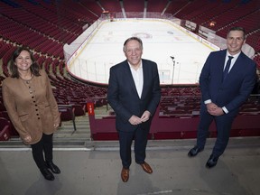 Quebec Premier François Legault is flanked by Isabelle Charest, the CAQ's point person on sports, and former NHL goaltender Marc Denis at the Bell Centre on Thursday.