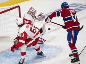 Canadiens' Nick Suzuki scores on Wings goaltender Alex Nedeljkovic  early in the first period Tuesday night as Wings' Moritz Seider looks on at the Bell Centre.