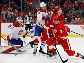 Canadiens goaltender Sam Montembeault (35) makes a save as defenceman Ben Chiarot (8) shoves Red Wings' Tyler Bertuzzi (59) and Dylan Larkin (71) in the second period at Little Caesars Arena in Detroit on Saturday, Nov. 13, 2021.