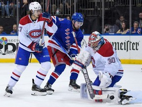 Canadiens goaltender Cayden Primeau makes a save against the Rangers' Alexis Lafrenière as Alexander Romanov defends during the second period Tuesday night at Madison Square Garden.