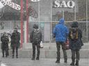 Kunden trotzen dem Schnee vor dem SAQ-Outlet des Jean-Talon Market im Jahr 2020.