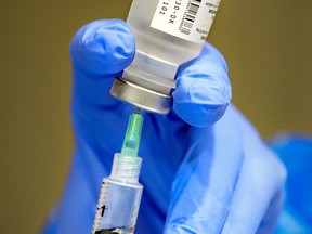 A syringe is filled with vaccine at a COVID-19 vaccination clinic.
