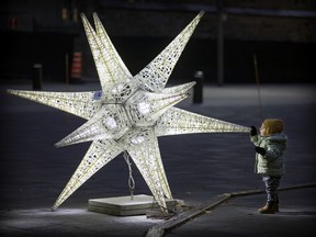 Hazel Magnias, 2, takes a closeup look at one of the holiday stars in Place D'Armes in Old Montreal last month.