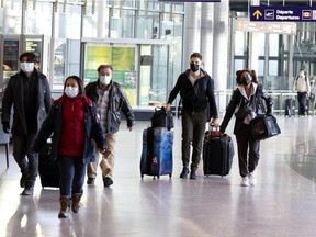 Travellers head towards check-in counters for flights departing from Trudeau International Airport in Montreal, on Monday, November 29, 2021.