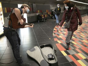 Busker Lucas Choi Zimbel receives a bit of coin at the Guy-Concordia métro station on Wednesday, December 1, 2021.