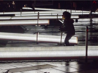 Gabriel Colley-King plays on illuminated see-saw, part of an installation that is called Impulsion, at the 12th edition of Luminothérapie in the Quartier des Spectacles.