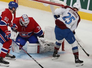 Colorado Avalanche's Logan O'Connor (25) tries for a rebound after shot on Montreal Canadiens goaltender Jake Allen, while Jonathan Drouin (92) follows into the play during first period action in Montreal on Thursday, Dec. 2, 2021.