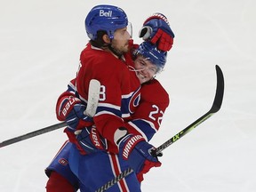 Montreal Canadiens' Cole Caufield (22) celebrates the goal of teammate Ben Chiarot (8) during second period in Montreal on Thursday, Dec. 2, 2021.