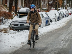 Yohei Mercier steers his bicycle up a slippery Melrose Ave. in the Notre-Dame-de-Grace district after the first significant snowfall of the season in Montreal, Dec. 6, 2021.