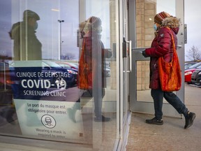 A couple enter a COVID-19 testing clinic in Kirkland on Dec. 7, 2021.