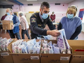 Snowflakes for Seniors founder Jan Lauer is joined by Daniel Lepore of T.M.R. public security and volunteers in assembling the gift bags. "I just felt that we had to do something for our seniors," Lauer says.