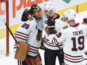 Chicago Blackhawks' Calvin de Haan, centre and Jonathan Toews congratulate goaltender Marc-André Fleury for his 500th career NHL win after shutting out the Montreal Canadiens 2-0 at the Bell Centre in Montreal on Dec. 9, 2021.
