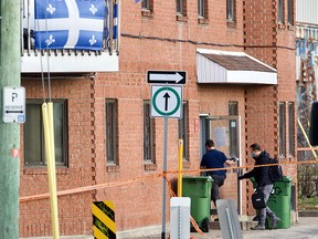 Two police investigators enter the scene of a homicide in a building at the corner of Ste-Marie St. and St-Joseph Blvd. in Lachine.