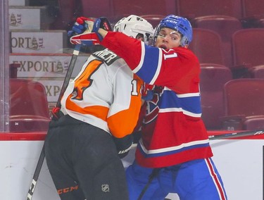 Montreal Canadiens' Jake Evans wraps up Philadelphia Flyers' Sean Couturier during first period at the Bell Centre on Thursday, Dec. 16, 2021.