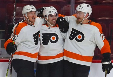 Philadelphia Flyers' Jackson Cates, centre, is congratulated by teammates Patrick Brown, left, and Rastus Ristolainen after scoring his first goal of the season during second period at the Bell Centre on Thursday, Dec. 16, 2021.