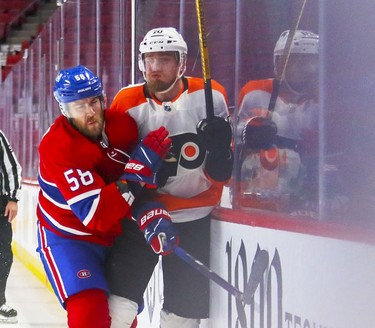 Montreal Canadiens' David Savard shoves Philadelphia Flyers' Rasmus Ristolainen into the boards during second period at the Bell Centre on Thursday, Dec. 16, 2021.
