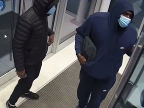 Surveillance camera footage shows two suspects in a deliberately set fire in an apartment block in the Laval's Ste-Dorothée district on Dec. 6, 2021.