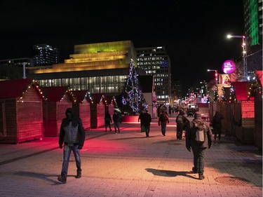 Montrealers walk on Ste- Catherine St. near the Luminothérapie installation, which will be in place until Feb. 27 at the Quartier des Spectacles.