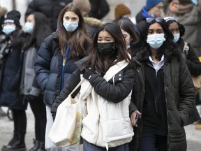 People walk down Ste Catherine street downtown on Monday December 20, 2021 after announcement of new COVID measures by Health Minister Christian Dube.