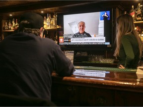 Staff and patrons at McLean's Pub on Peel St. in Montreal listen to Health Minister Christian Dubé announce new COVID measures, including the closing of bars as of 5 p.m. on Monday, December 20, 2021.