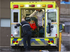 Paramedics load a woman into an ambulance outside the emergency department at St. Mary’s Hospital on Dec. 21, 2021.